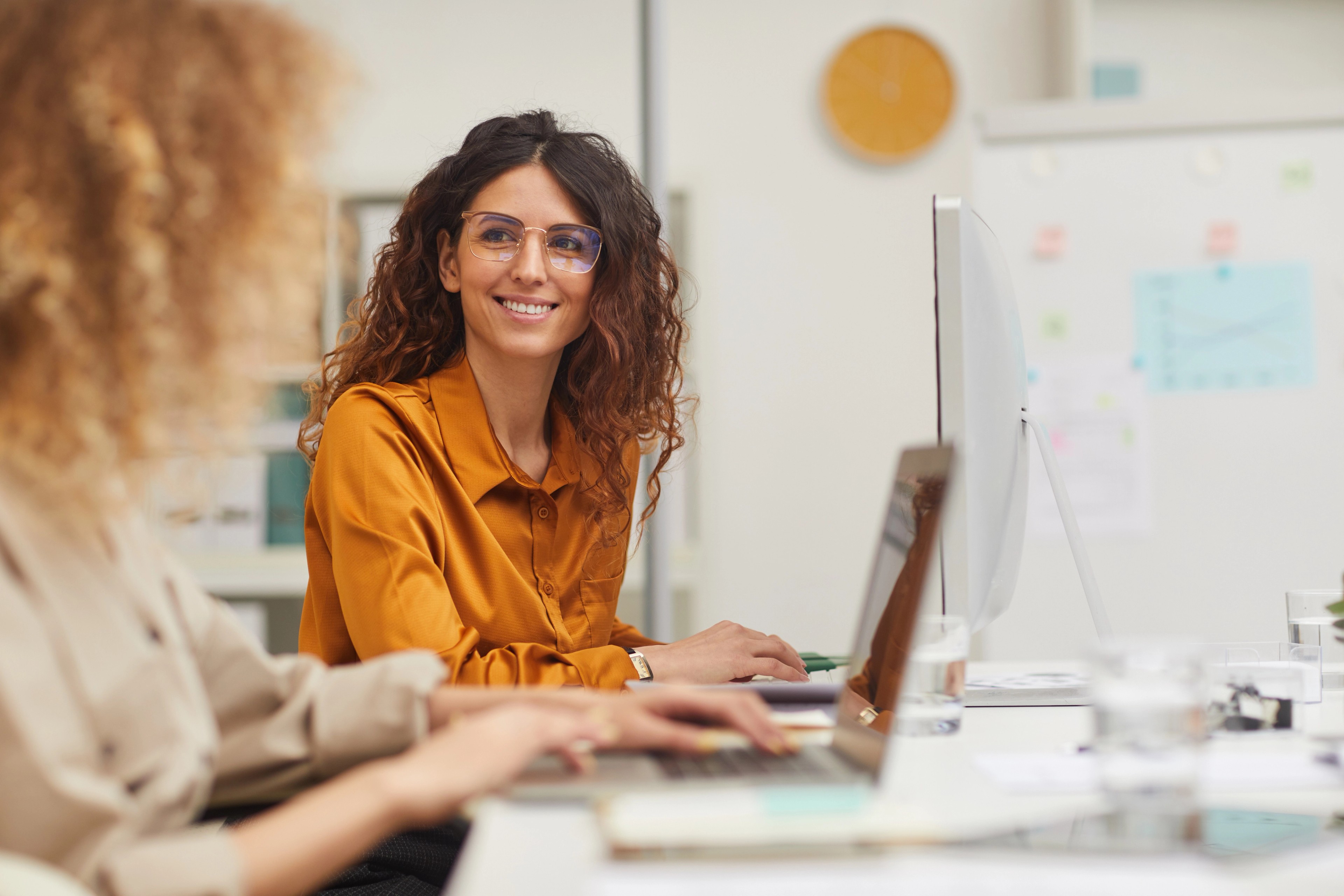 female colleagues interacting while working in office